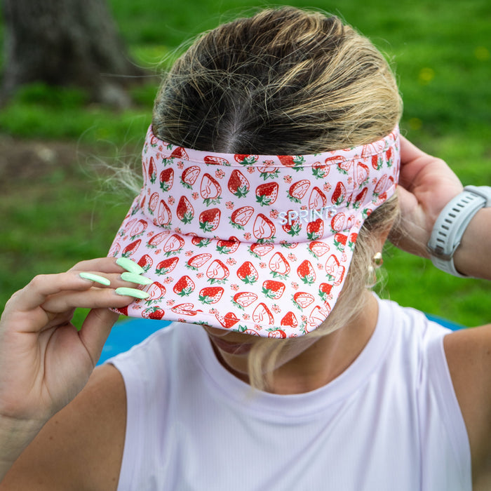Runner wearing the Berry Fast Strawberry Visor with pink strawberry print