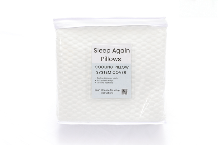 A packaged Cooling Fitted Sheet for the Sleep Again Pillow System with a textured white surface, label highlighting cooling jacquard fabric, soft inner cover, machine washability, and QR code—ideal for hot sleepers or pairing with a cooling pillow cover.