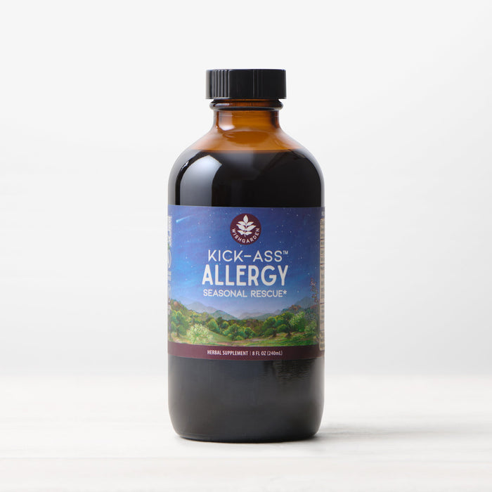 A bottle of Kick-Ass Allergy, Seasonal Rescue liquid herbal tincture with a scenic label rests on a light surface against a white background—ideal for natural allergy relief.