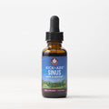 A 1 fl oz (30 ml) amber glass dropper bottle of Kick-Ass Sinus, Move & Soothe herbal supplement rests on a light surface with a white background—an herbal remedy for upper respiratory support.