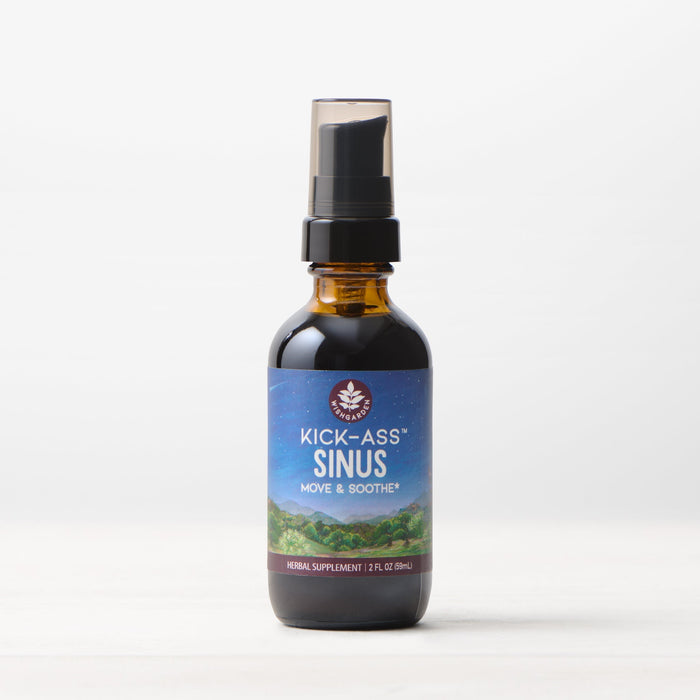 A brown bottle with a black spray cap labeled Kick-Ass Sinus, Move & Soothe sits on a white surface—a natural herbal choice for sinus and upper respiratory support.