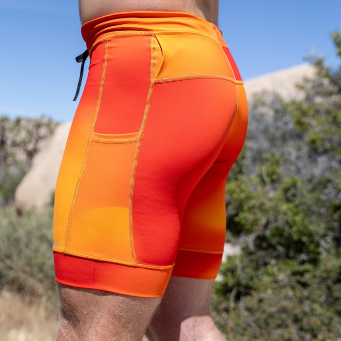 Man wearing the Flexion 8 inch Half Tights in Orange Crush, close-up