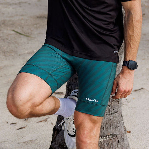 Man wearing the Flexion 8 inch Half Tights in Velocity Blitz Green