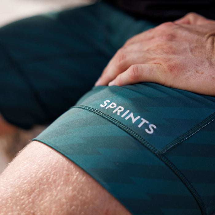 Man wearing the Flexion 8 inch Half Tights in Velocity Blitz Green, close-up