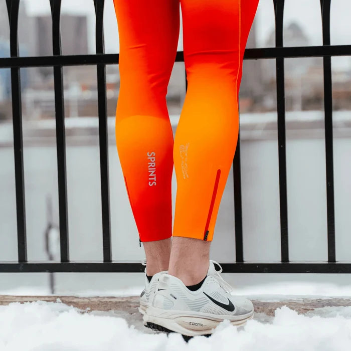 Man wearing the Flexion Max Compression Tights in Orange Crush, running