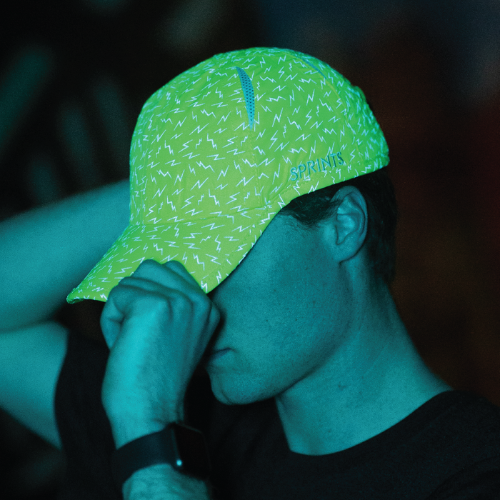 Man wearing neon green hat with lightning bolts