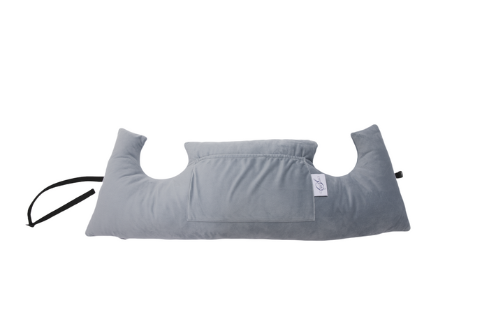 The Chest Pillow is a light gray, U-shaped pillow featuring a central pocket and attached black strap, designed for breast surgery recovery. It is displayed against a white background.