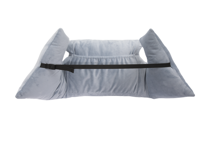 The Chest Pillow is light gray, plush, and features two large side supports, a black adjustable front strap, and a central pocket for positioning and stability after breast surgery. Shown on a white background.