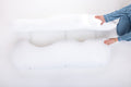 Two hands showing 3 pillow straps attached to side pillows on a light background