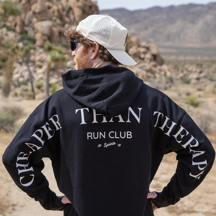 Person wearing the Run Club Oversized Hoodie in Cheaper than Therapy Black