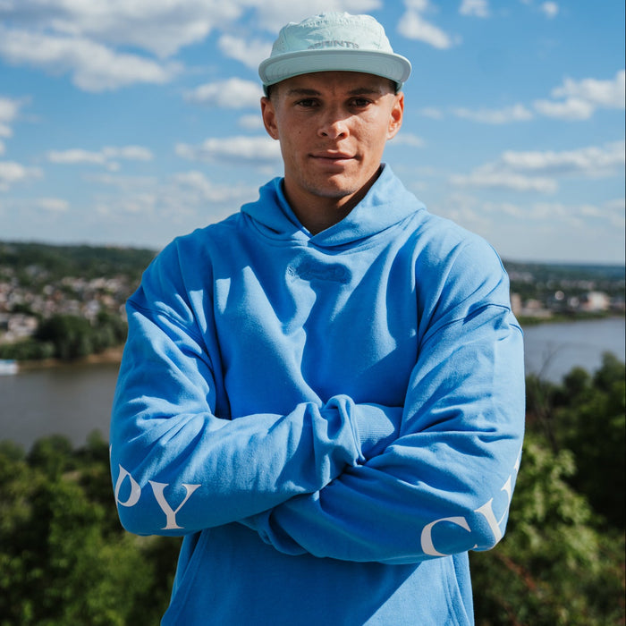 Person wearing the Run Club Oversized Hoodie in Cheaper than Therapy Blue, close-up