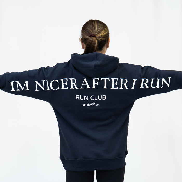 Person wearing the Run Club Oversized Hoodie in I'm Nicer After I Run Navy, close-up