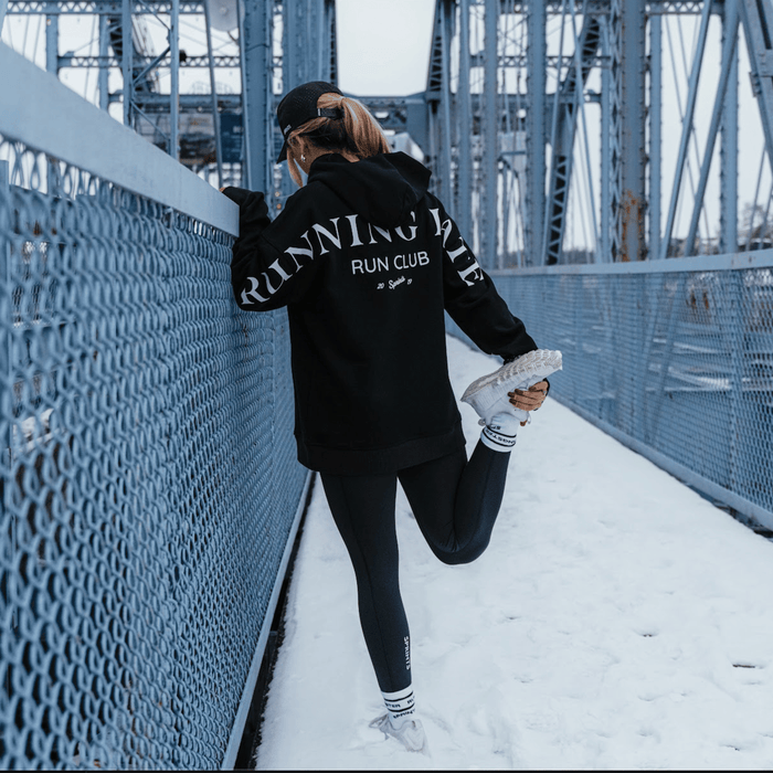 Person wearing the Run Club Oversized Hoodie in Running Late Black, close-up