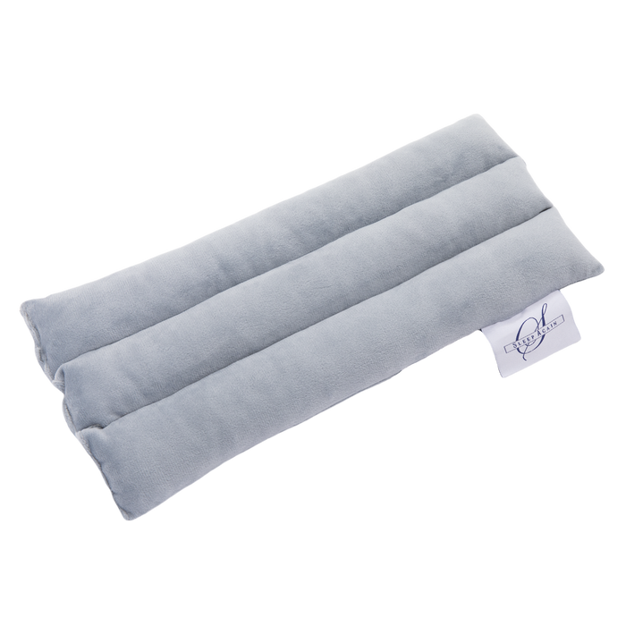 A rectangular, light gray Seat Belt Pillow with three sections and a small white tag showing a logo and text. Designed for chest support during surgery recovery, it is displayed on a plain white background.