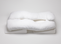 The Sleep Again Pillow System is a large, white U-shaped body pillow with a headrest, offering ergonomic support for arms, legs, and head. HSA and FSA eligible, it rests on a white surface for optimal comfort.