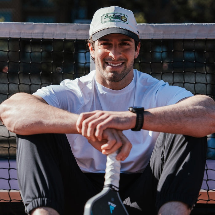Person wearing the Social Dinker EZ Rope Snapback while playing pickleball