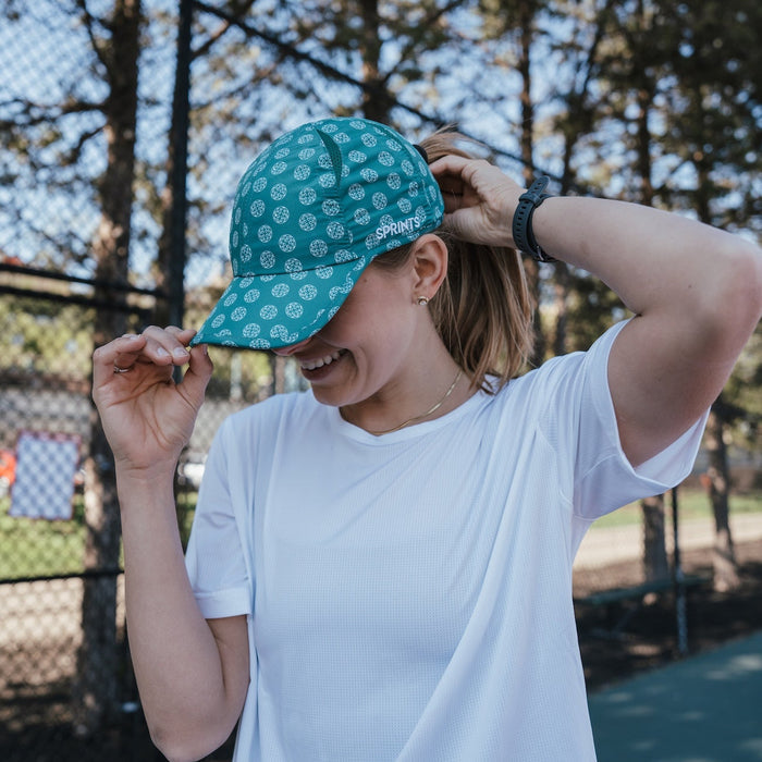 Person wearing the Social Dinker OG Hat while playing pickleball