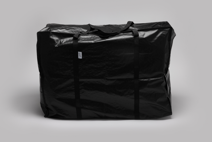 The Travel and Storage Bag for Sleep Again Pillow System is a large, black, water-resistant bag with two handles. Spacious and durable, it stands upright against a gray background—perfect for organizing essentials on the go.