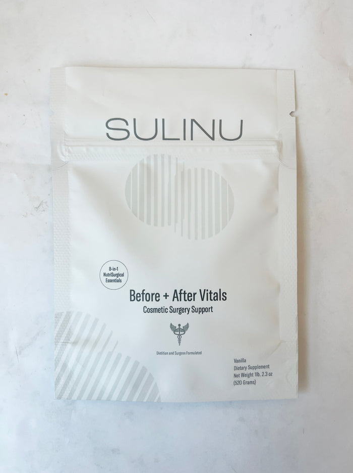 A set of 5 single-serving Travel Packs labeled SULINU Before + After Vitals with vanilla flavor and a minimalist, silver-accented design lies on marble—ideal as a pre and post-surgery supplement for wound healing.