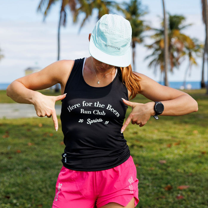 Woman wearing the Core Zero Running Tank in Here For The Beers Run Club Black, side view
