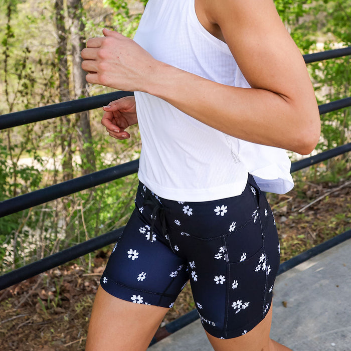 Woman wearing the Flexion 5 inch Compression Short in Florid Declamation print, side view
