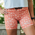 Woman wearing the Flexion 5 inch Compression Short in Lagoon Coral