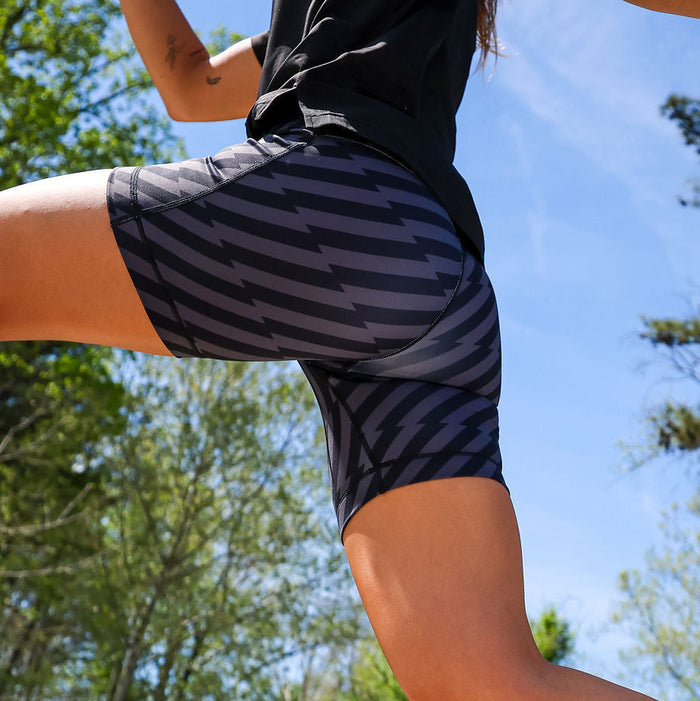 Woman wearing the Flexion 5 inch Compression Short in Velocity Blitz Black, close-up