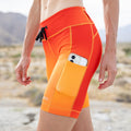 Woman wearing the Flexion 8 inch Compression Short in Orange Crush